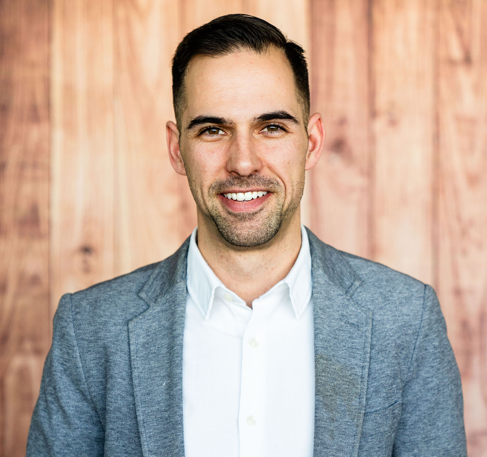 A photo of STU alumnus Jason Cassidy standing in front of a wood panelled wall