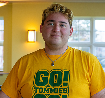 Picture of student in study hall with Go Tommies T-shirt