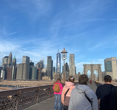 A group of students walking across the Brooklyn Bridge
