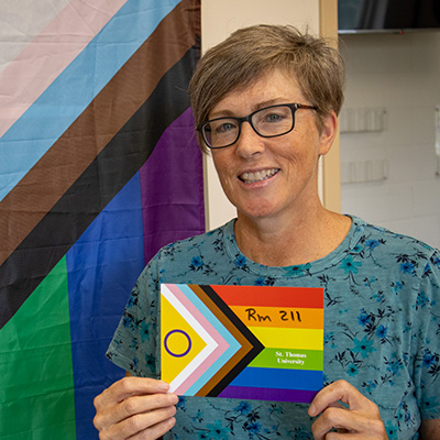 Gail Costello holding an 2SLGBTQ+ sign