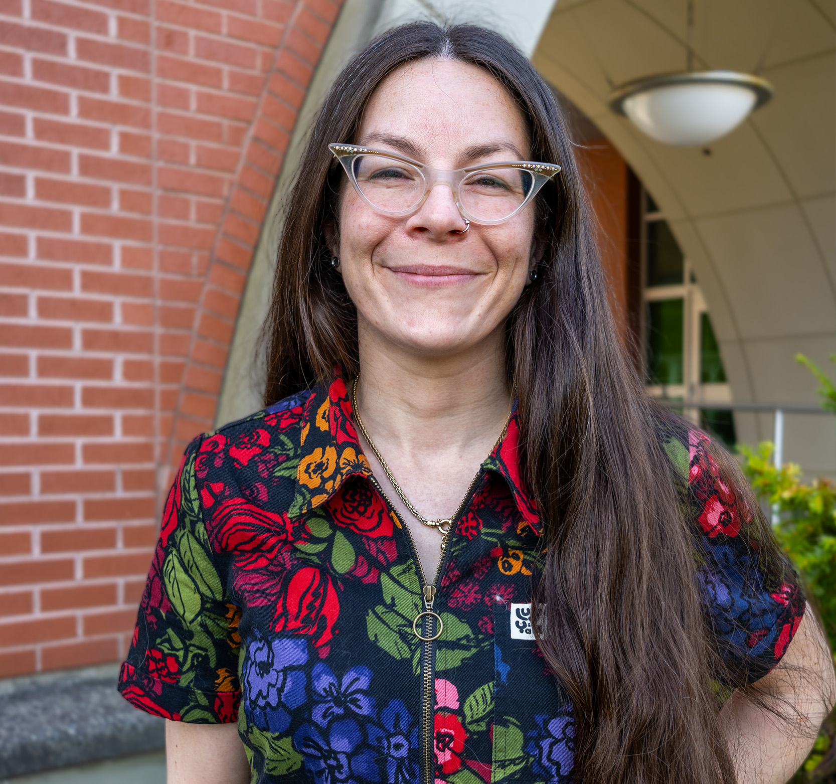Dr. Margaret Campbell, standing outside on campus in front of a brick building